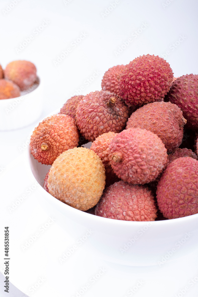 Lychee fruits on in a white plate on a light background Lychee fruits on in a white plate on a light background