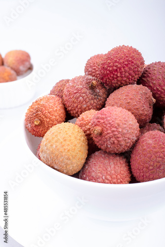 Lychee fruits on in a white plate on a light background
