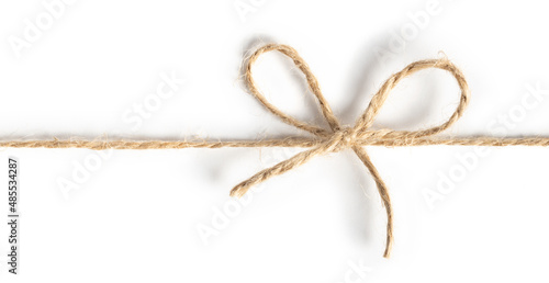 Closeup of twine tied in a bow on white background
