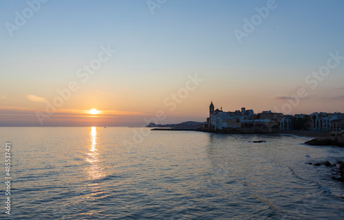 Picturesque sea evening landscape. Sunset over the mediterranean sea. Evening city, sea and sunset. The sun is above the horizon line.