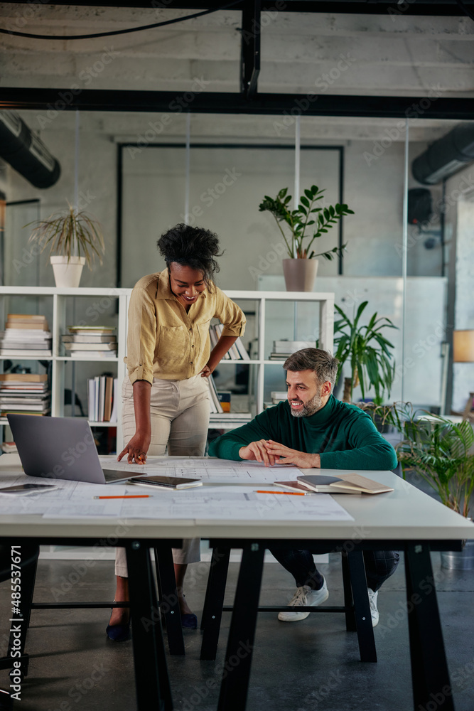 Diverse business couple having a discussion in an office Diverse business couple having a discussion in an office