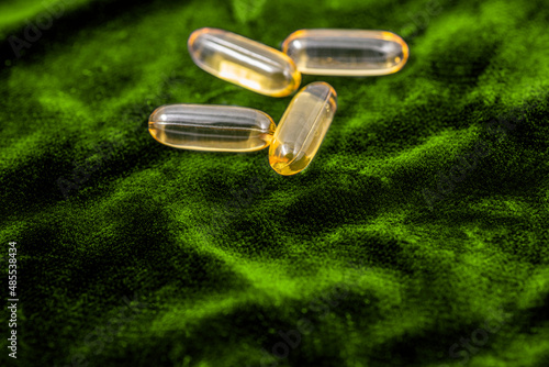 Fish oil capsules on a dark blue plush cloth