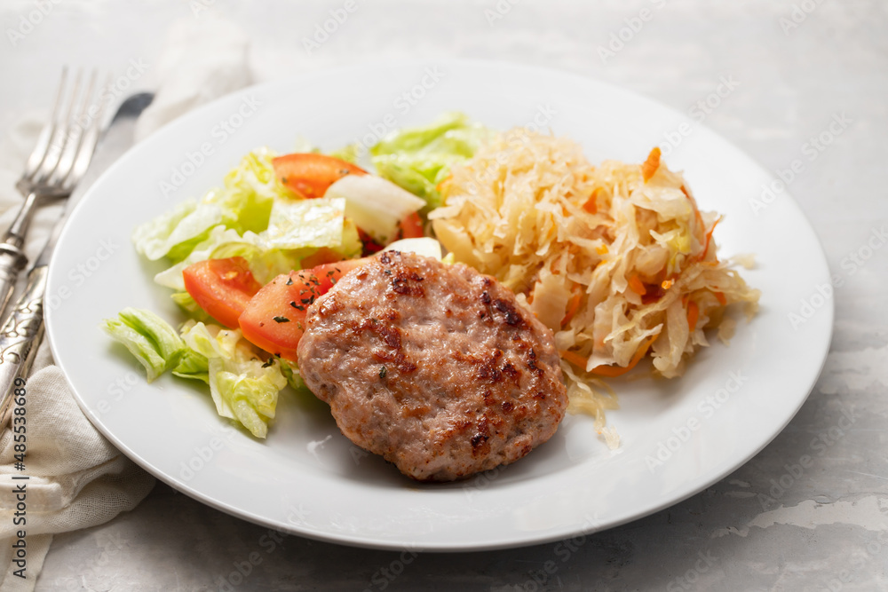 grilled hamburger with salad and salted salas cabbage withcarrot on white plate