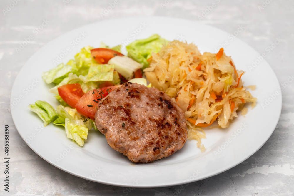 grilled hamburger with salad and salted salas cabbage withcarrot on white plate grilled hamburger with salad and salted salas cabbage withcarrot on white plate