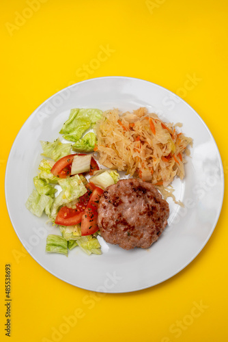 grilled hamburger with salad and salted salas cabbage withcarrot on white plate