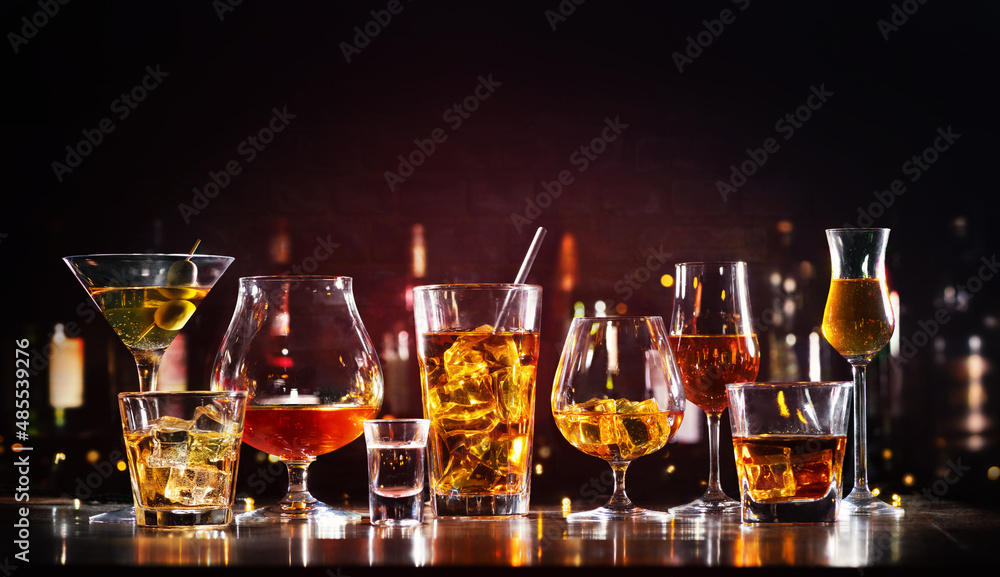 Assortment of hard strong alcoholic drinks and spirits in glasses on bar counter - obrazy, fototapety, plakaty 