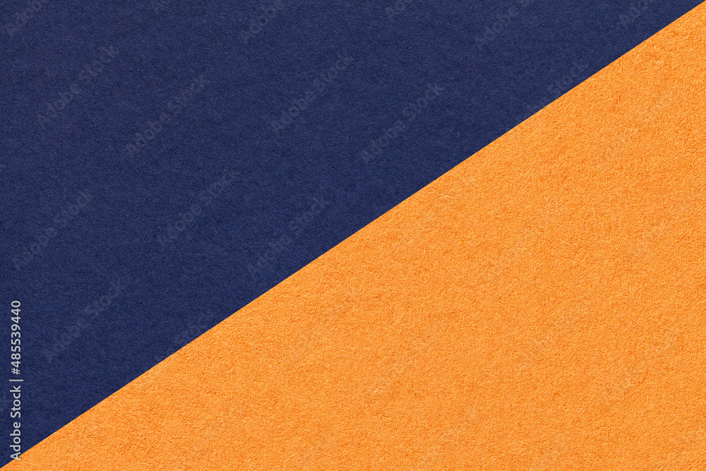Fototapeta premium Texture of navy blue and orange paper background, half two colors, macro. Structure of indigo kraft cardboard.