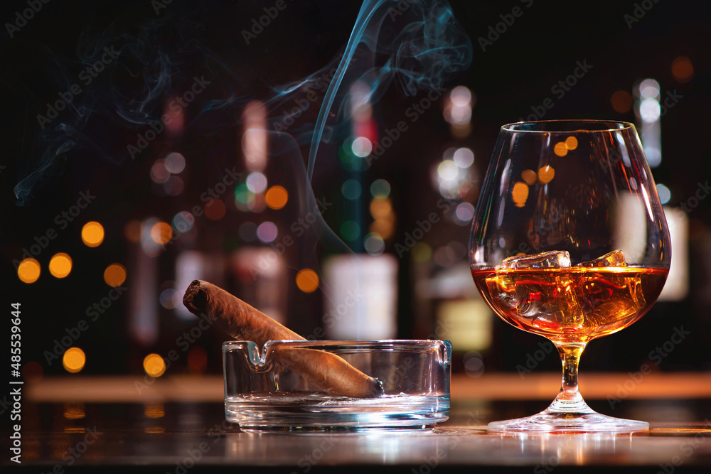 Glass of whiskey or cognac with ice cubes and smoking cigar - obrazy, fototapety, plakaty 