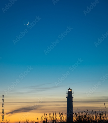 View of the lighthouse of Torrox at sunset, is a lighthouse that is located on the coast of the municipality of Torrox, Malaga, Andalusia, Spain. photo