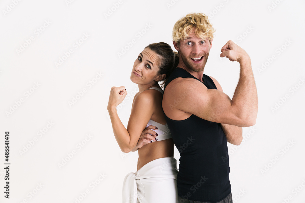 European couple in sportswear showing their biceps at camera European couple in sportswear showing their biceps at camera