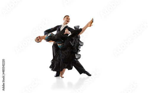 One young graceful artistic couple, man and woman dancing ballroom dance isolated over white studio background. Beauty, art, sport concept