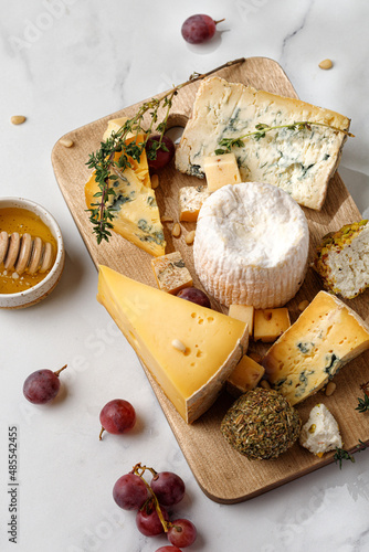 Assortment of cheese shropshire , langre, asiago, gorgonzola, shanklish cheese. Cheese plate with fruit, honey.