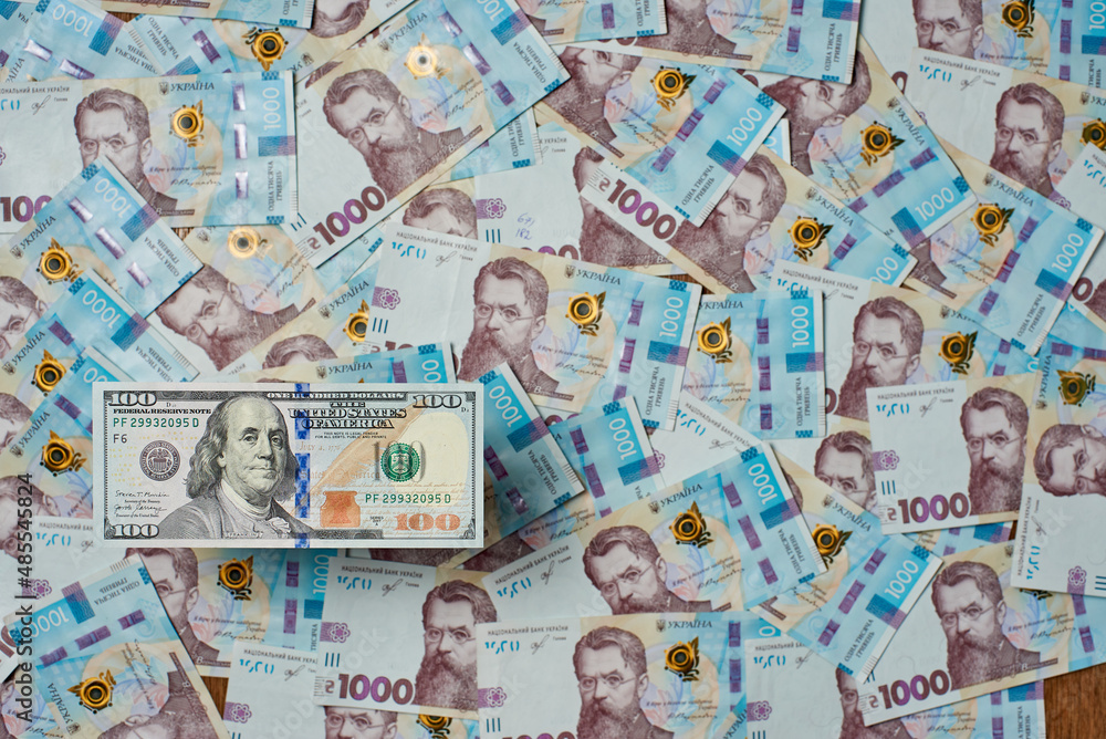 Image of $ 100 bills against the background of Ukrainian money.