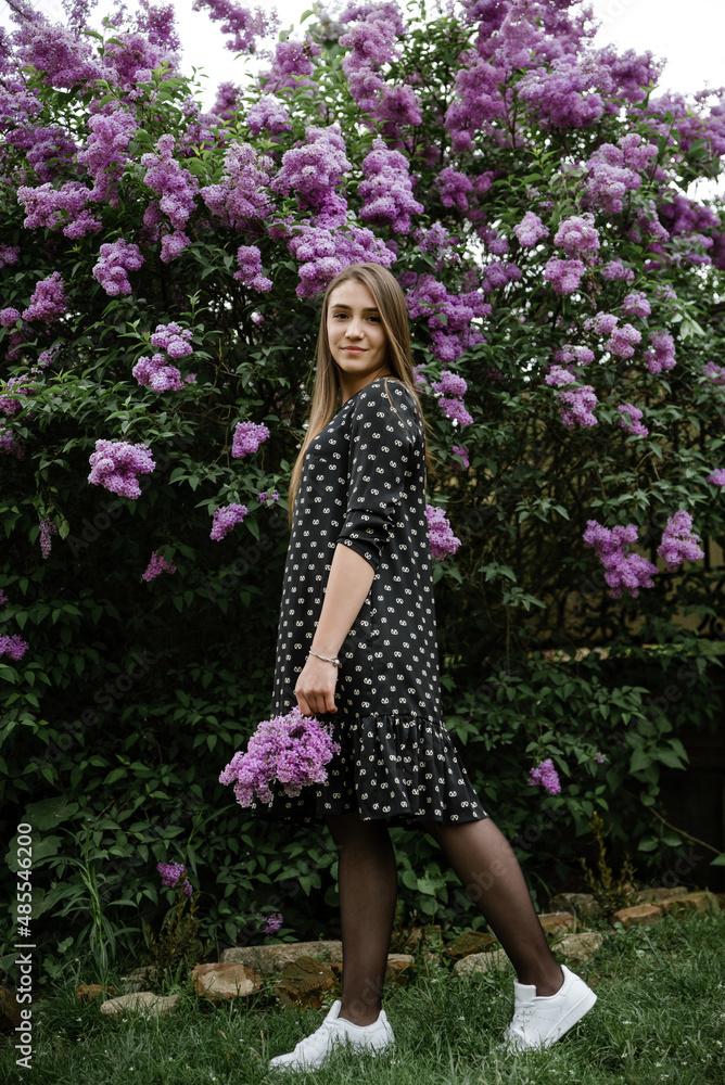 portrait of a beautiful girl in lilac flowers in the garden. spring time. portrait of a beautiful girl in lilac flowers in the garden. spring time.