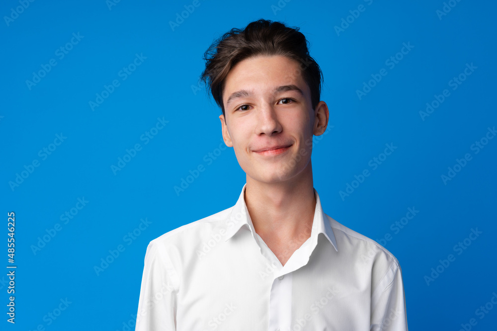 Portrait of a smiling teen boy against blue background Portrait of a smiling teen boy against blue background