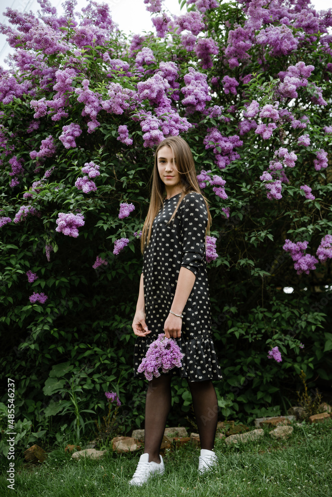 portrait of a beautiful girl in lilac flowers in the garden. spring time. portrait of a beautiful girl in lilac flowers in the garden. spring time.
