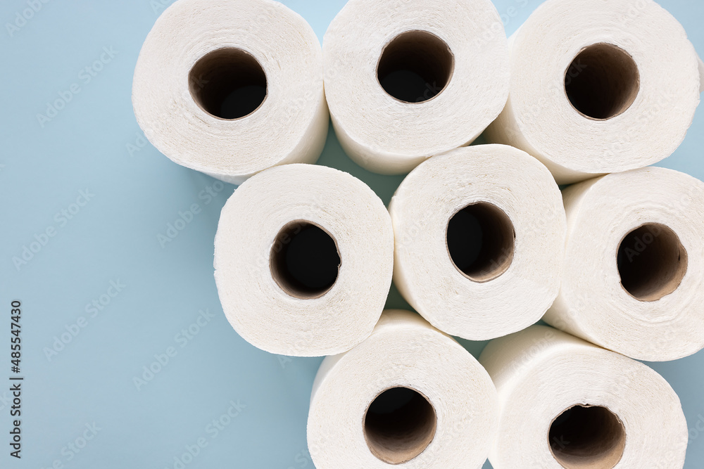 Fresh new white toilet paper rolls on blue background. Personal hygiene and health issues concept. Top view, copy space Fresh new white toilet paper rolls on blue background. Personal hygiene and health issues concept. Top view, copy space