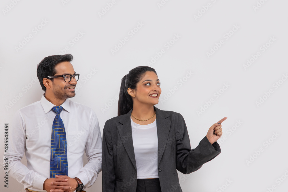 Portrait of a beautiful corporate couple looking and pointing elsewhere Portrait of a beautiful corporate couple looking and pointing elsewhere