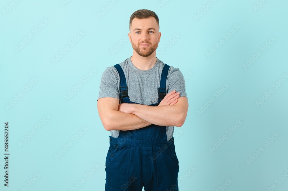 Fototapeta premium Handsome young craftsman over isolated blue background