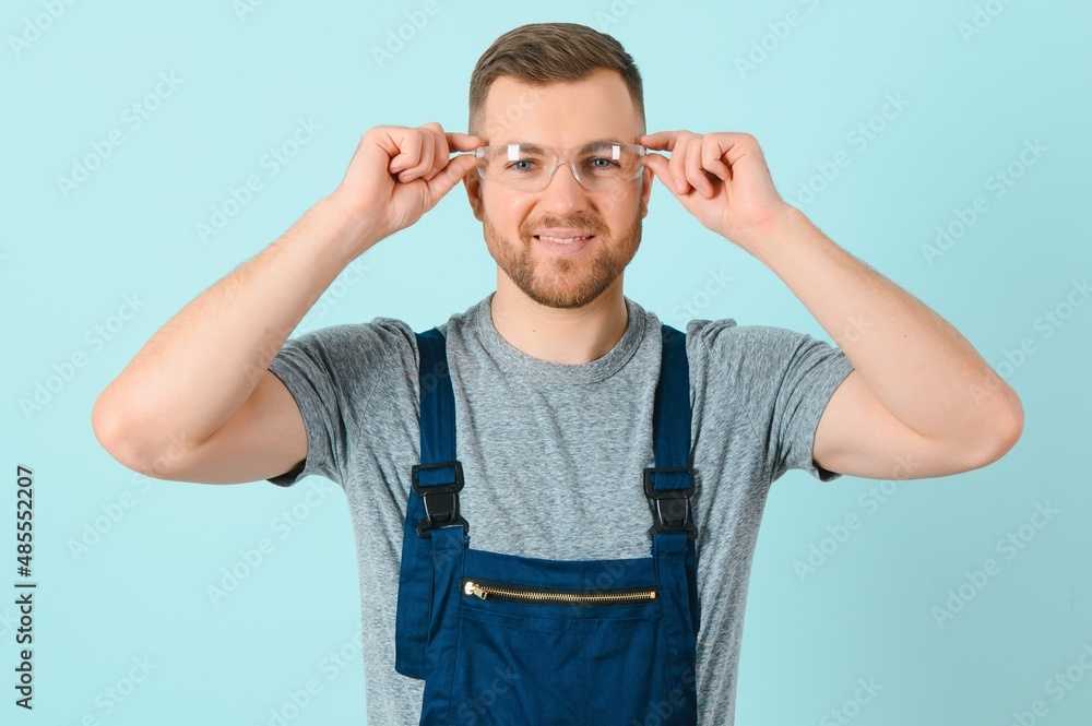 Handsome young craftsman over isolated blue background Handsome young craftsman over isolated blue background