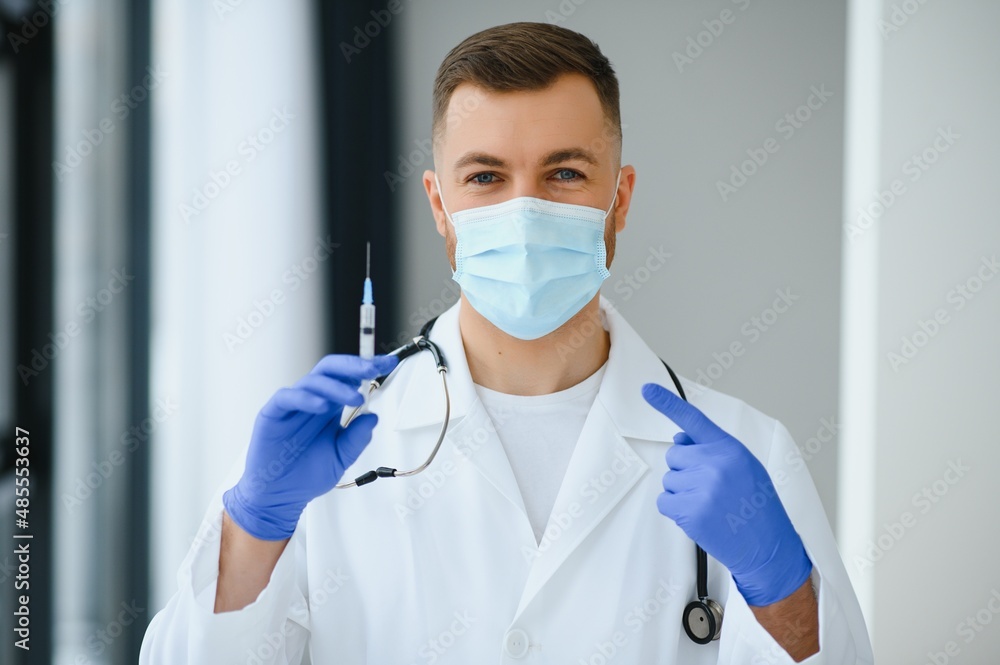A doctor in blue gloves holding a bottle with vaccine. Close up shot. Medicine and healthcare concept A doctor in blue gloves holding a bottle with vaccine. Close up shot. Medicine and healthcare concept