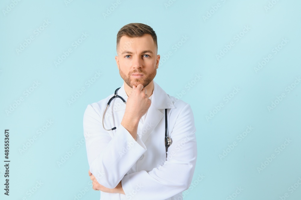 handsome doctor man wearing coat and stethoscope over isolated blue background. handsome doctor man wearing coat and stethoscope over isolated blue background.