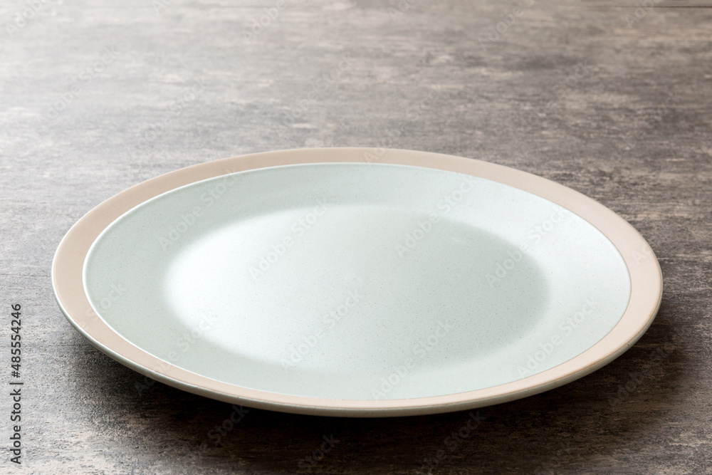 Perspective view of empty light plate on cement background. Empty space for your design Perspective view of empty light plate on cement background. Empty space for your design