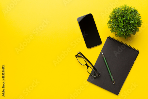Smartphone with a notebook on a light Color background. top view