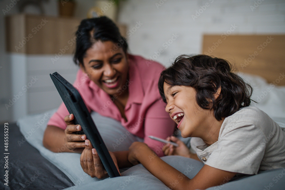 Indian mother using tablet with her little son and having fun at home. Indian mother using tablet with her little son and having fun at home.