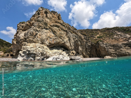 Underwater split photo of natural exotic island rocky bay with turquoise crystal clear sea and small caves