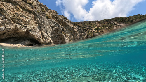 Underwater split photo of beautiful paradise pebble rocky bay of Kaladi with turquoise crystal clear sea and small caves  Kythira island  Ionian  Greece