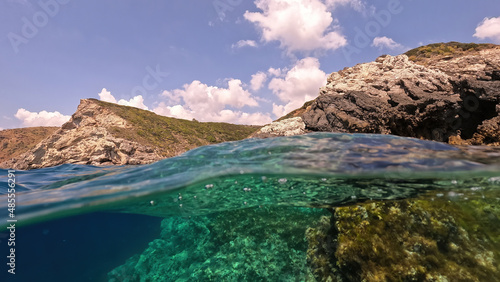 Underwater split photo of beautiful paradise pebble rocky bay of Kaladi with turquoise crystal clear sea and small caves, Kythira island, Ionian, Greece photo