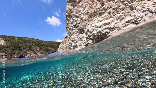 Underwater split photo of beautiful paradise pebble rocky bay of Kaladi with turquoise crystal clear sea and small caves, Kythira island, Ionian, Greece photo