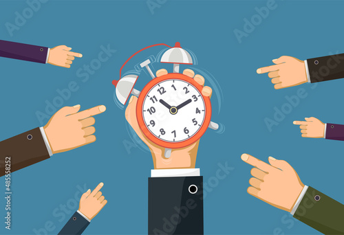 Businessman holding a ringing alarm clock.
