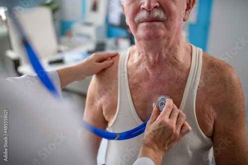 Close-up of unrecognizable senior man being checked by his doctor in doctor's office.