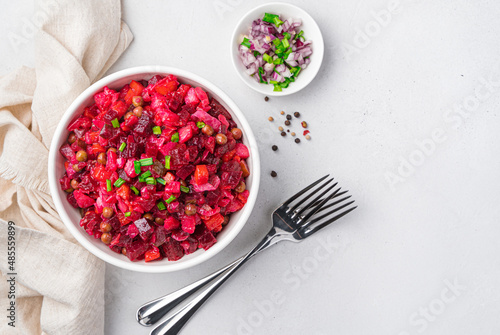 Salad vinaigrette with vegetables and fresh herbs on a light background. photo