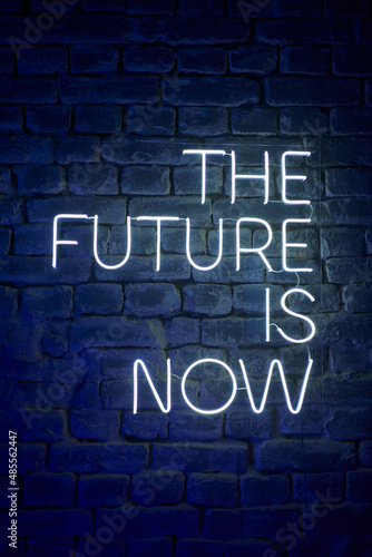 neon glowing inscription on the wall the future is now