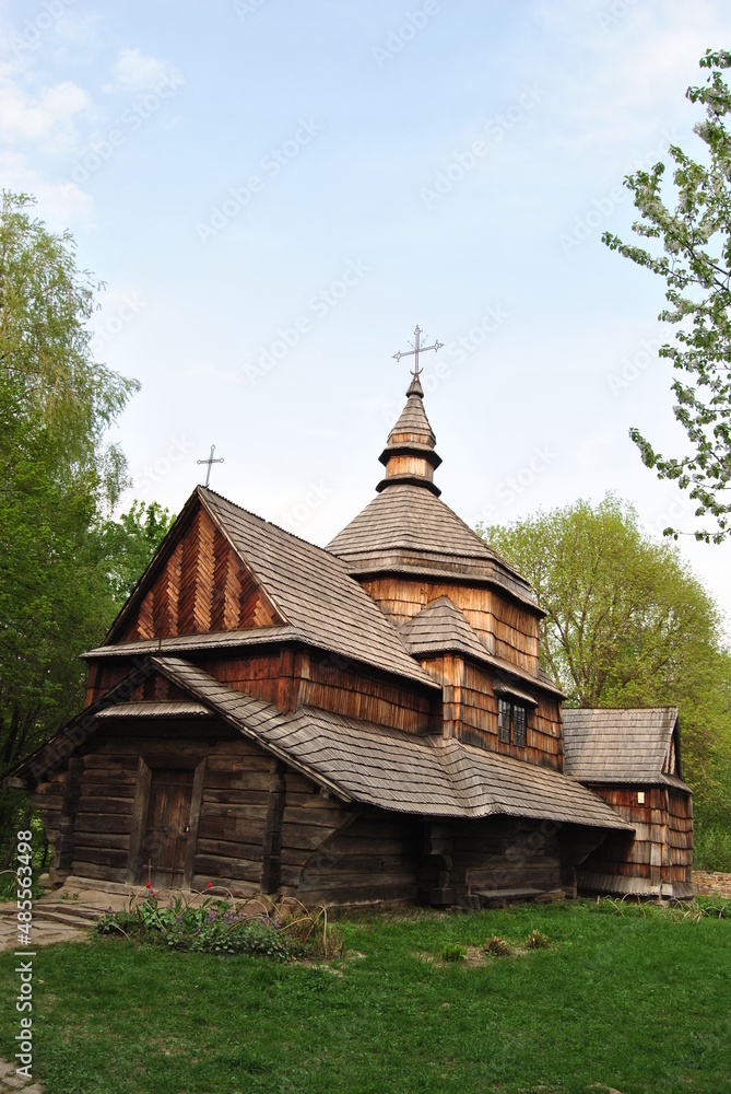 An old wooden church in Ukraine. Rural landscape with a church. Wooden Ukrainian church. The green landscape of the countryside. Kiev. Ukraine. An old wooden church in Ukraine. Rural landscape with a church. Wooden Ukrainian church. The green landscape of the countryside. Kiev. Ukraine.