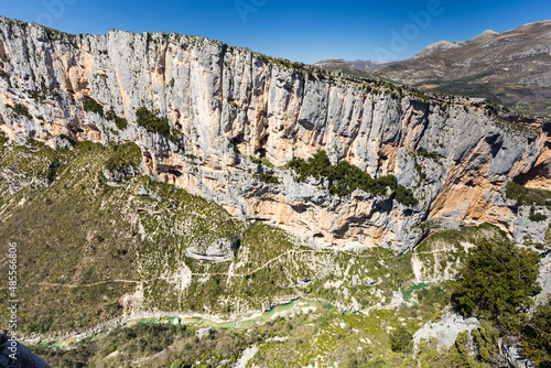 Falaise calcaire verticale formant un canyon avec un sentier et une rivière émeraude dans le fond. Site d'escalade, Barres de l'Escalès et sentier Blanc-Martel, Gorges du Verdon, France