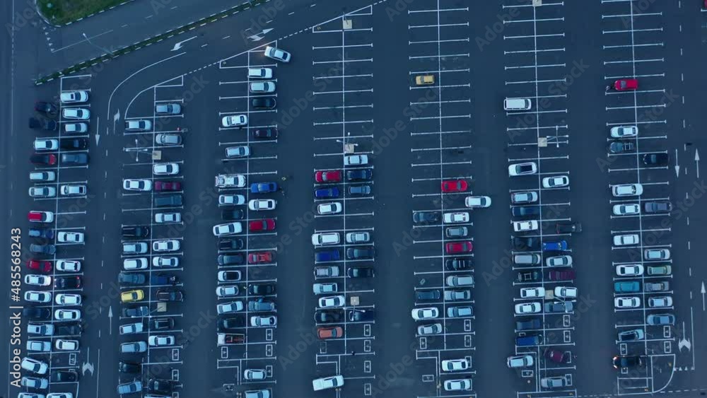 Aerial top view on mall parking with many cars at dusk, 4k