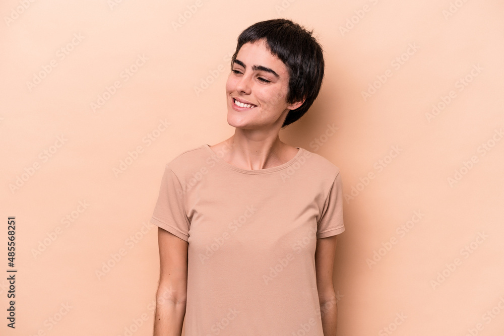 Young caucasian woman isolated on beige background relaxed and happy laughing, neck stretched showing teeth. Young caucasian woman isolated on beige background relaxed and happy laughing, neck stretched showing teeth.