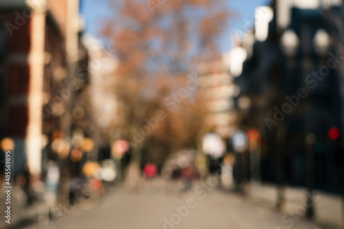 Natural bokeh of city cantre view, blurred out of focus background. Abstract beautiful backdrop for text or advertising. Unfocused cafes, buildings and people