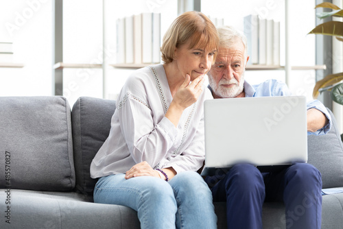 senior couple using laptop computer on sofa