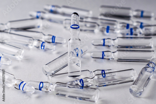 randomly lying and standing ampoules with medicines on a white background
