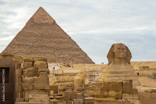 Sphinx and The Great Pyramid of Chephren (also known as Pyramid of Khafre or Khafra) on the background. It is second-tallest and second-largest of the Ancient Egyptian Pyramids of Giza, Cairo, Egypt. 