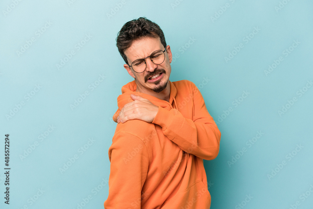 Young caucasian man isolated on blue background having a shoulder pain. Young caucasian man isolated on blue background having a shoulder pain.