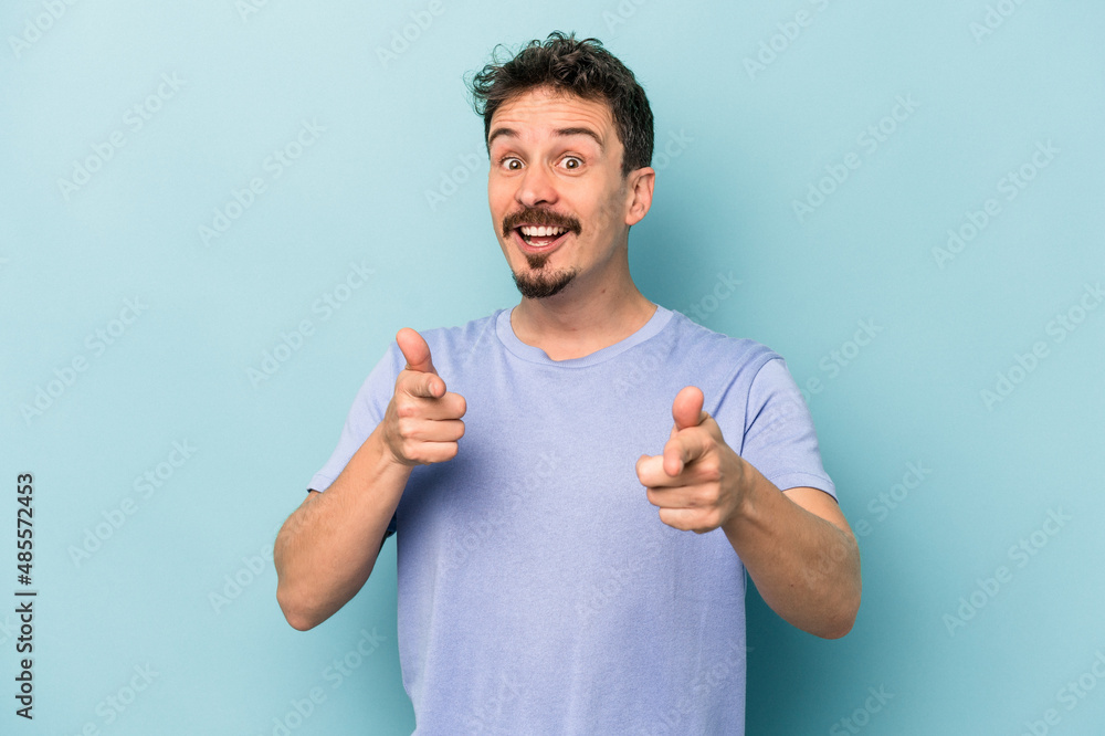 Young caucasian man isolated on blue background cheerful smiles pointing to front. Young caucasian man isolated on blue background cheerful smiles pointing to front.