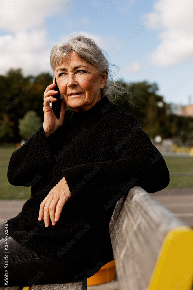 © Johnér - Senior woman using cell phone in park © Johnér - Senior woman using cell phone in park