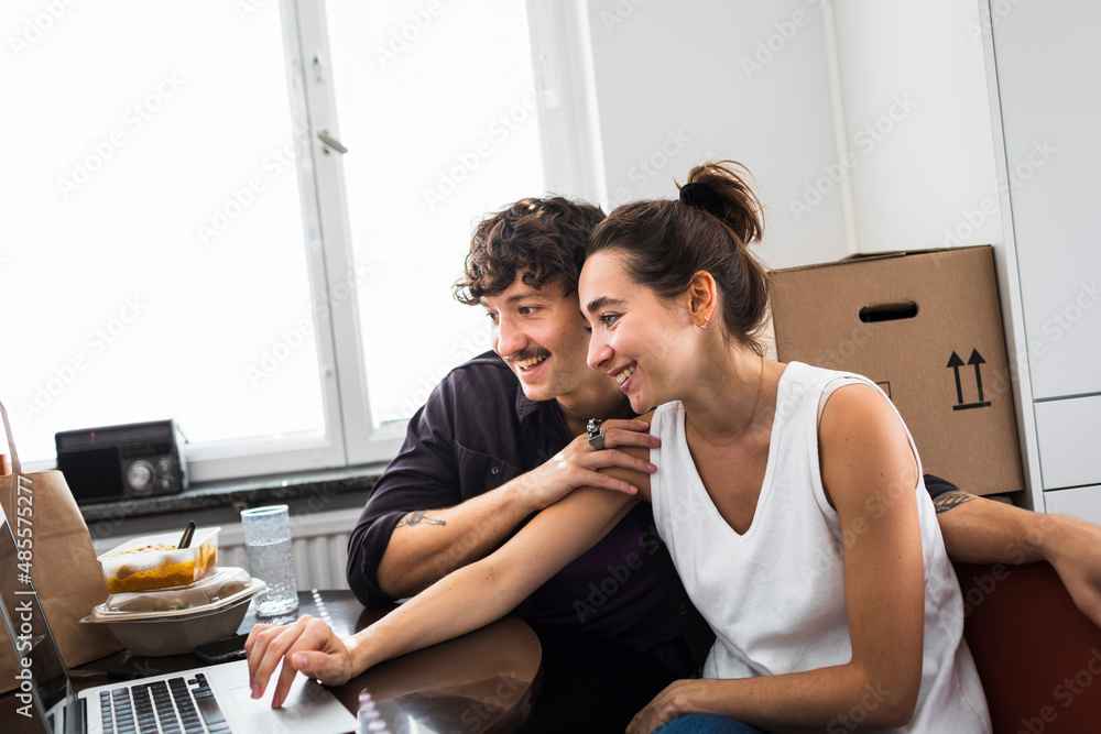 Couple sitting at table and using laptop Couple sitting at table and using laptop