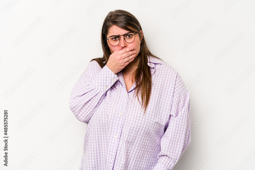 Young caucasian overweight woman isolated on white background covering mouth with hands looking worried.
